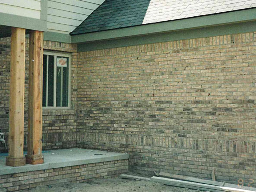 The porch wall in 1998 before the work, the brick beside two cedar posts running darker through the lower courses and the soldier band, with a camera date of 8/28/98 in the corner