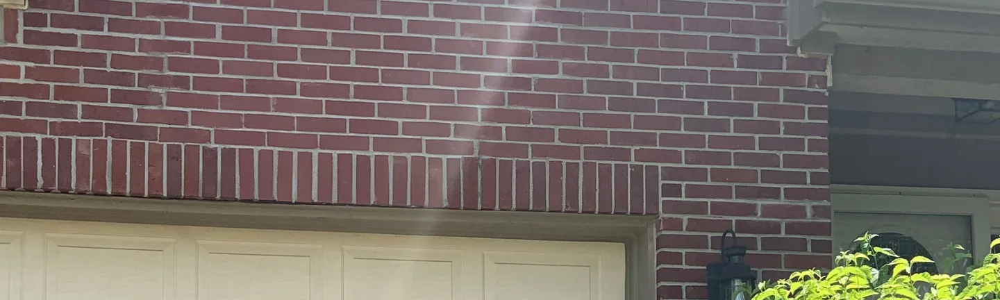 The brick front of a Fishers house in 2019, a deep red wall running to a soldier course above the garage opening
