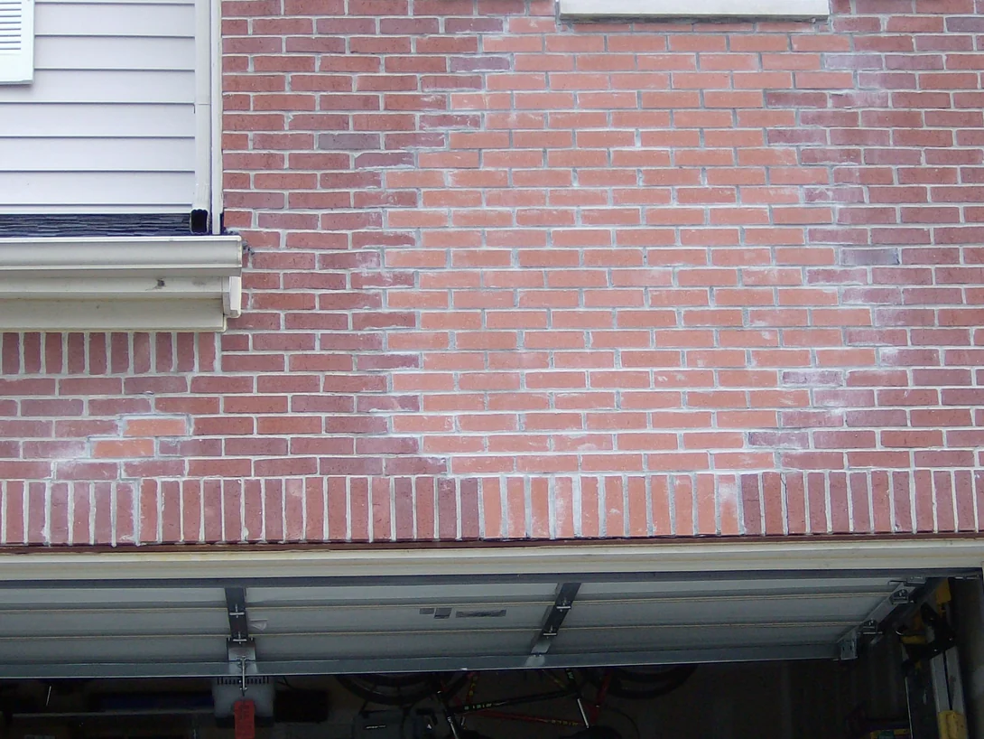 The brick above the garage in 2007, a pale pinkish red under bright white mortar joints, with a soldier course running over the opening