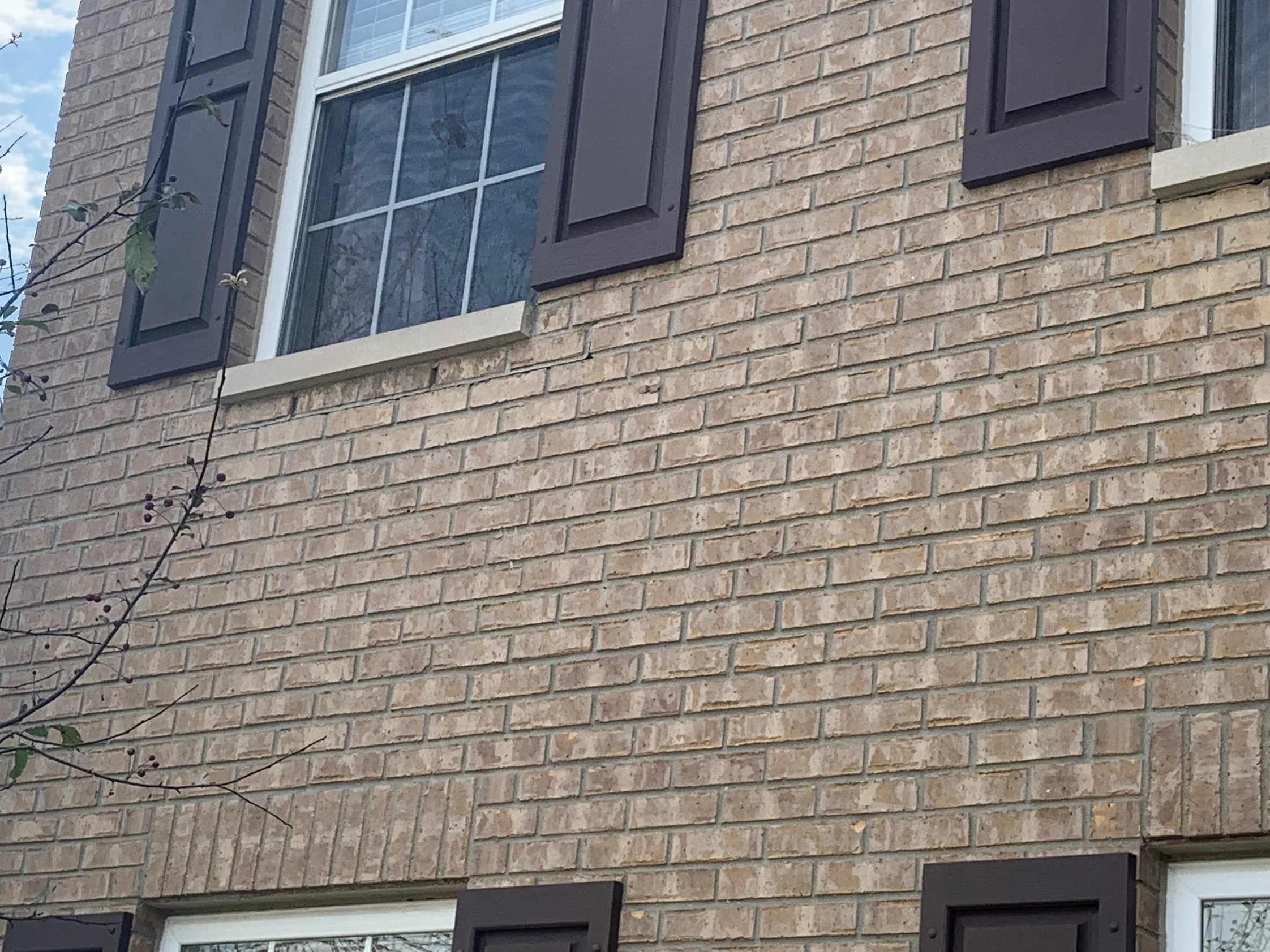 The brick field under two upper windows in 2019, the units below the sills reading as one range with the wall around them