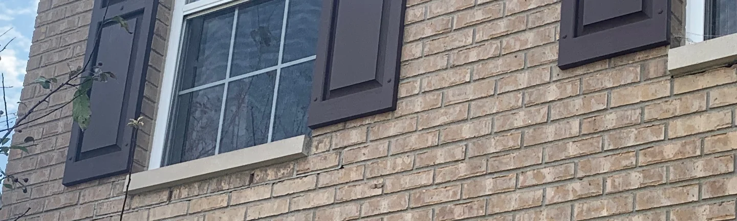 A band of brick under the windows of a Fishers house in 2019, the units below the sills reading as one range