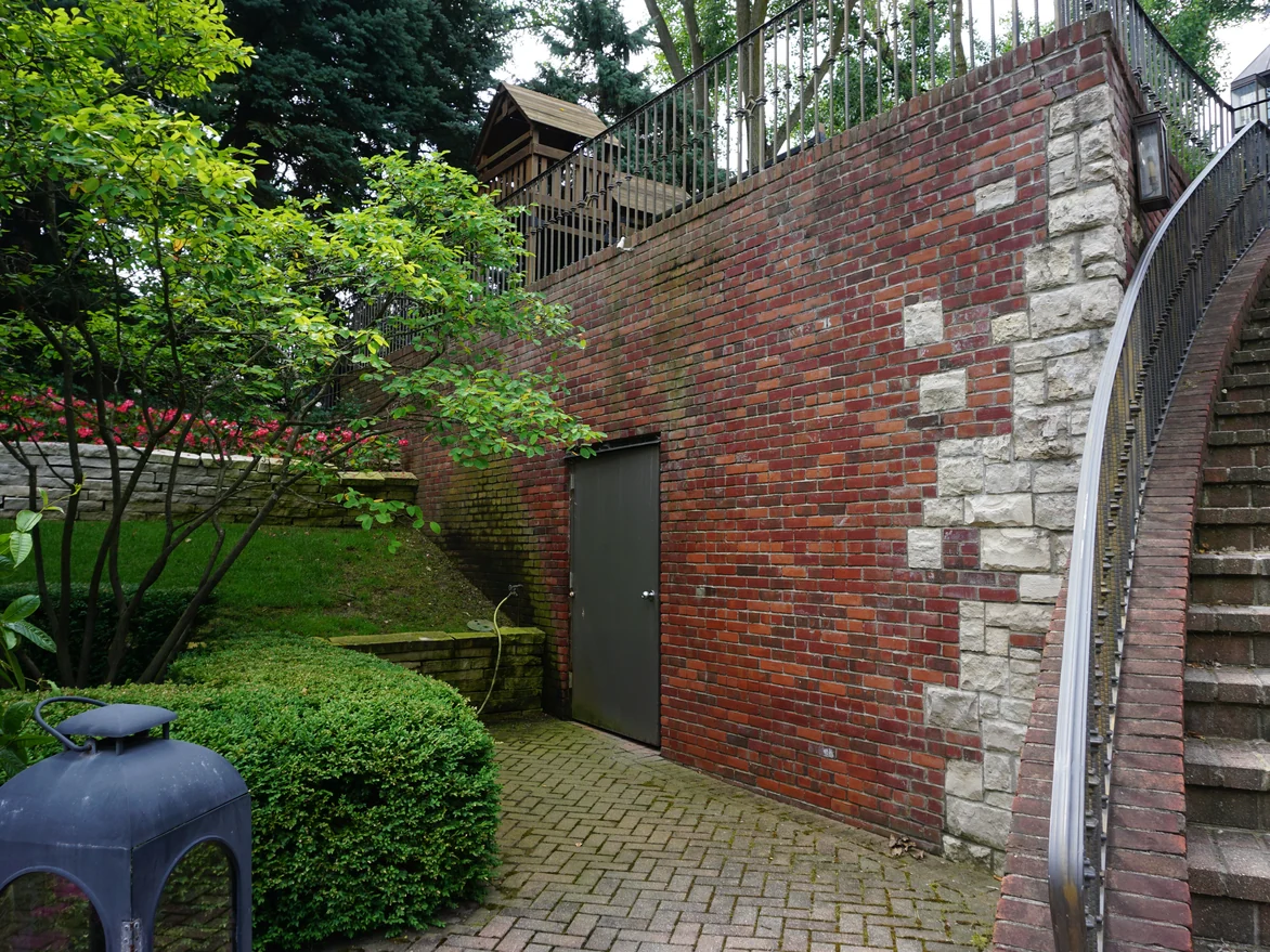 A close view of the terrace retaining wall in 2019, its brick mixed red and brown against blocks of limestone