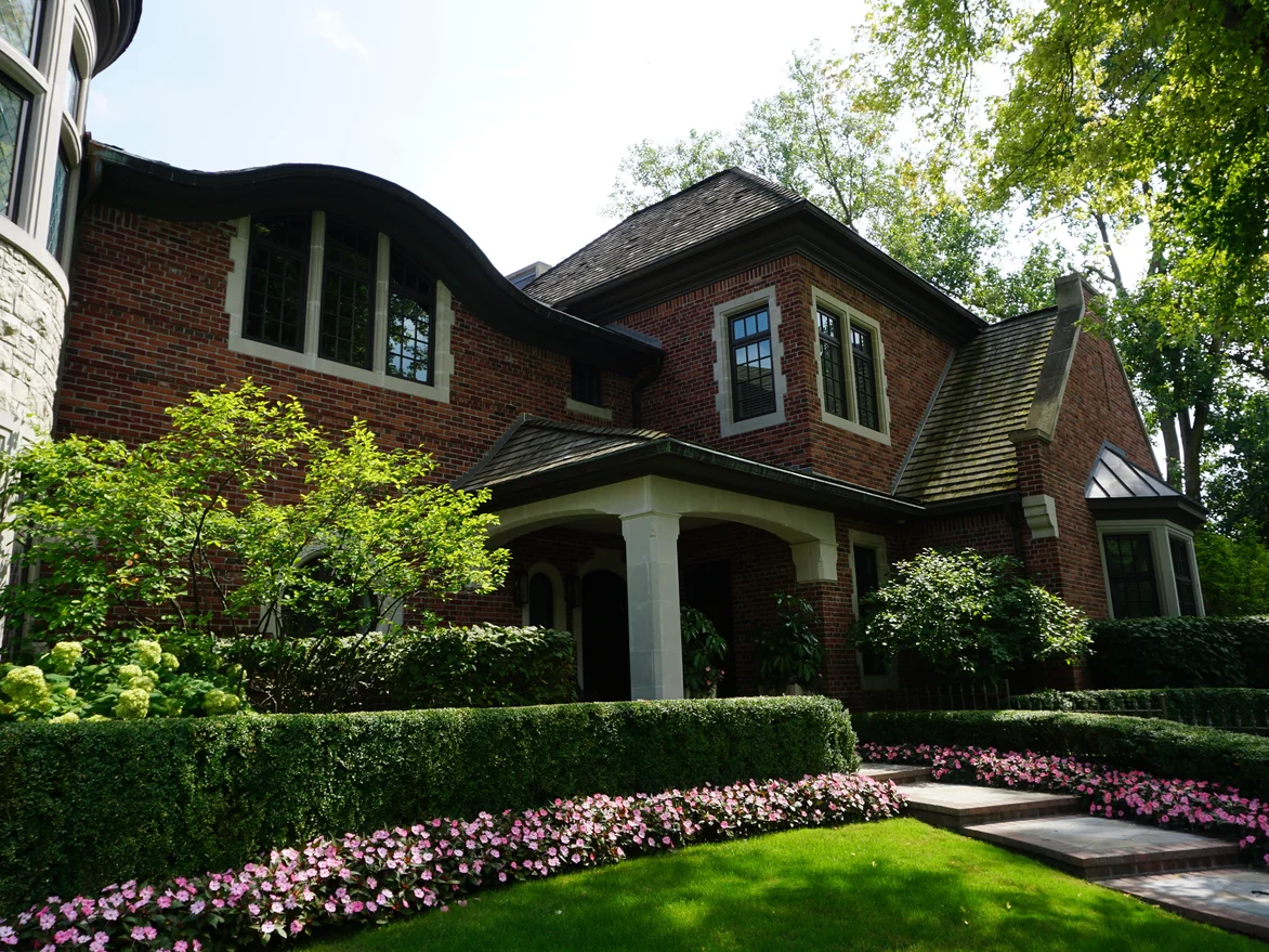 The front entry porch under a curved roof in 2019, the brick around it an even mix of reds and browns