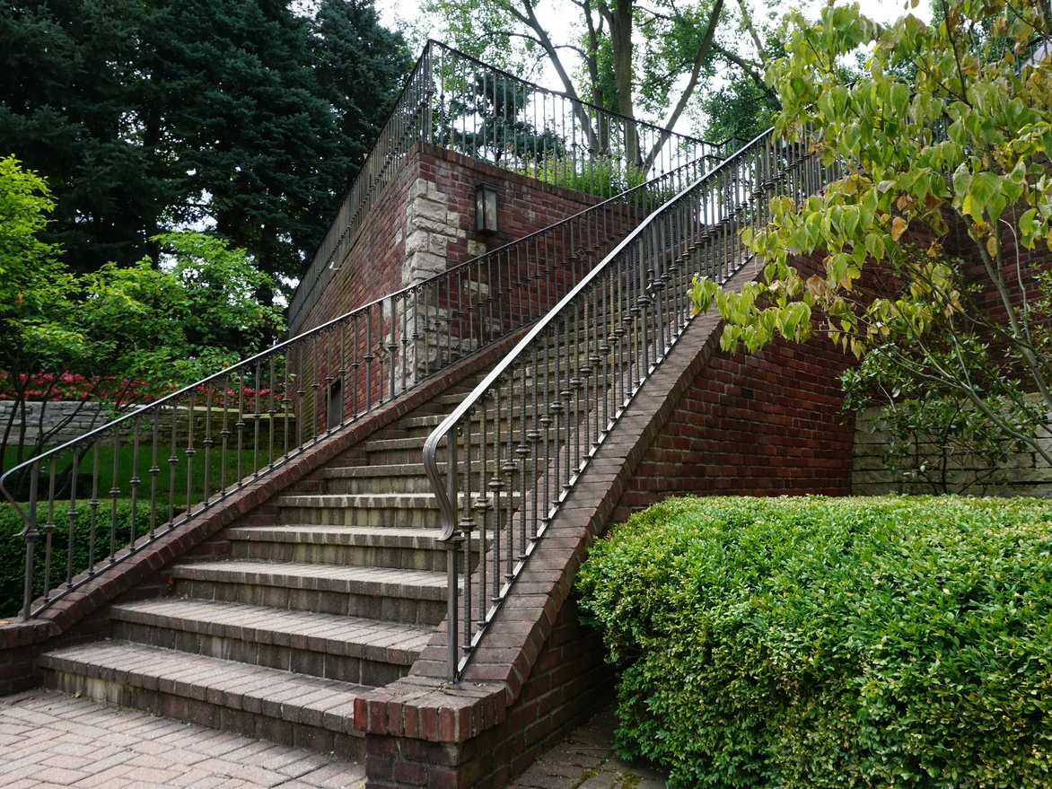 The brick garden stair and its iron railing running up the face of the terrace wall in 2019