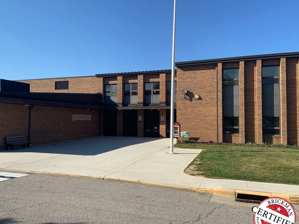The front of the school in 2019 from the kerb, the two story classroom wing and the low entrance range reading as one even red brown brick.