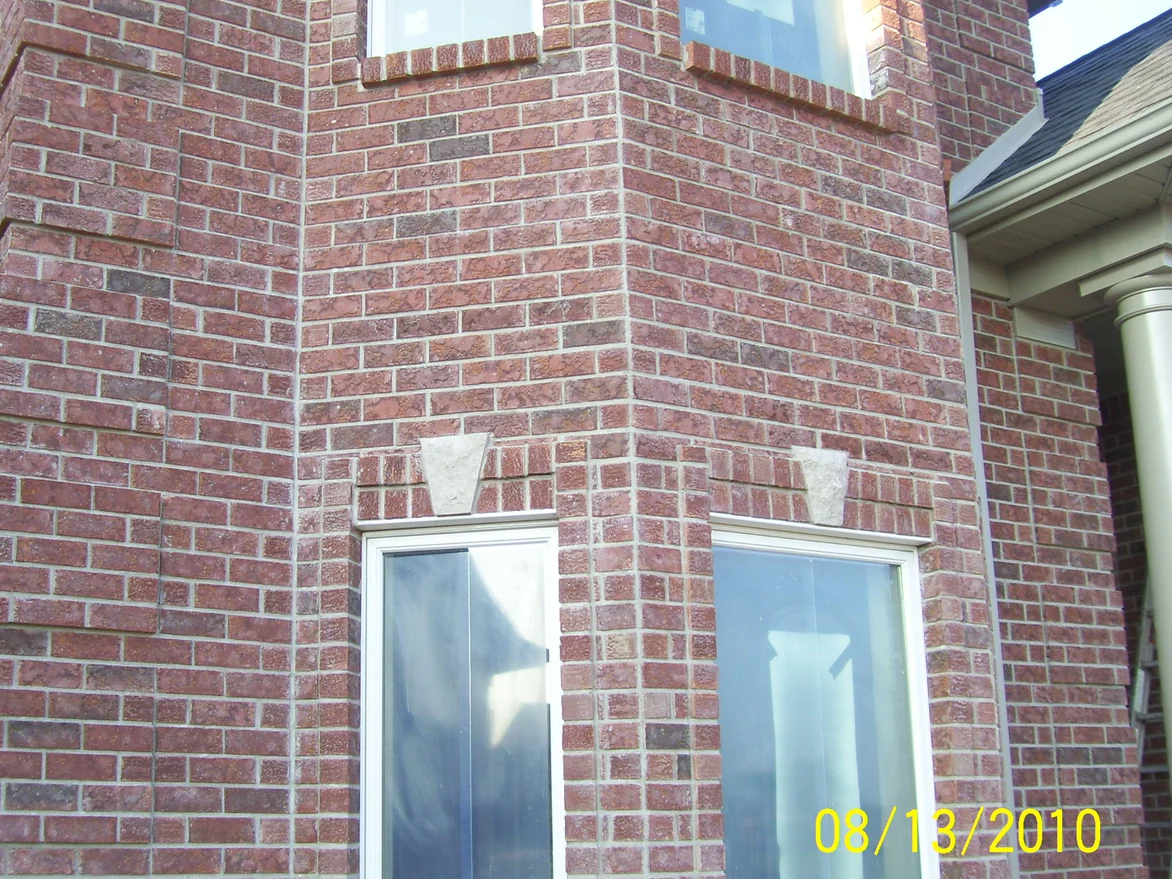 The same bay window later on August 13, 2010, the scattered light units darkened so the wall reads as one red brown range from the upper windows down to the keystones