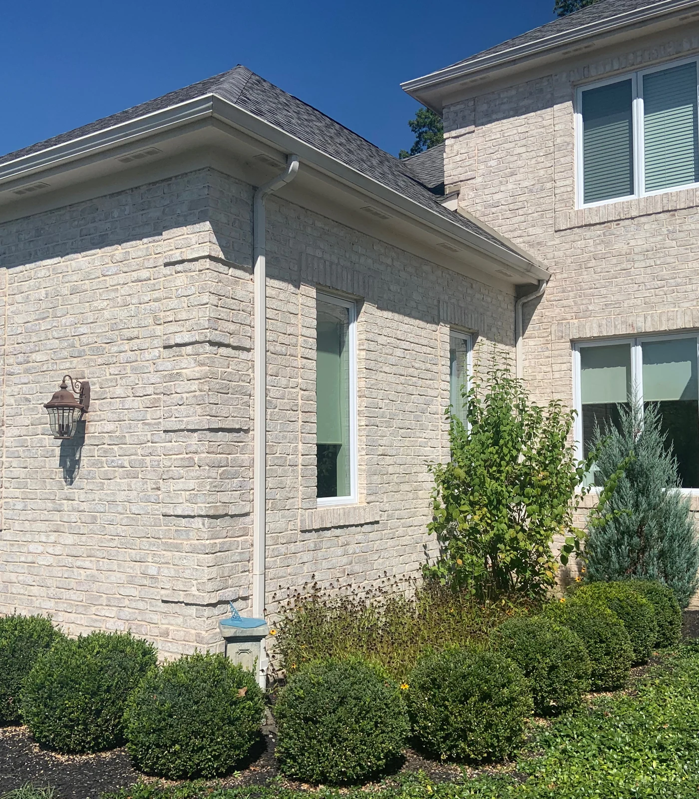 The corner of a two-story home in Galena, Ohio in 2019, its brick an even cream eight years after staining