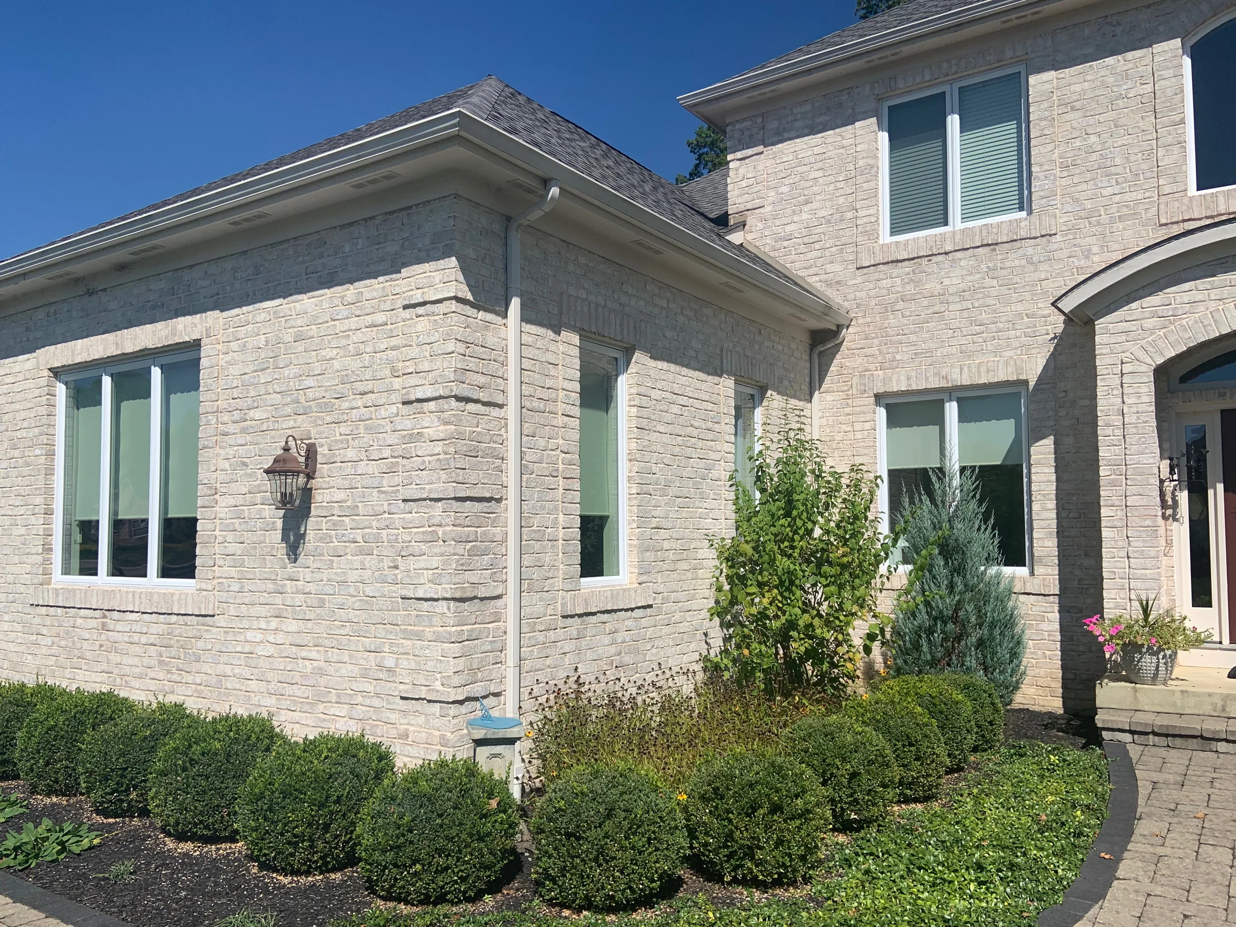 An outside corner of the single-story wing in 2019, the brick running evenly around both faces under a wall lamp