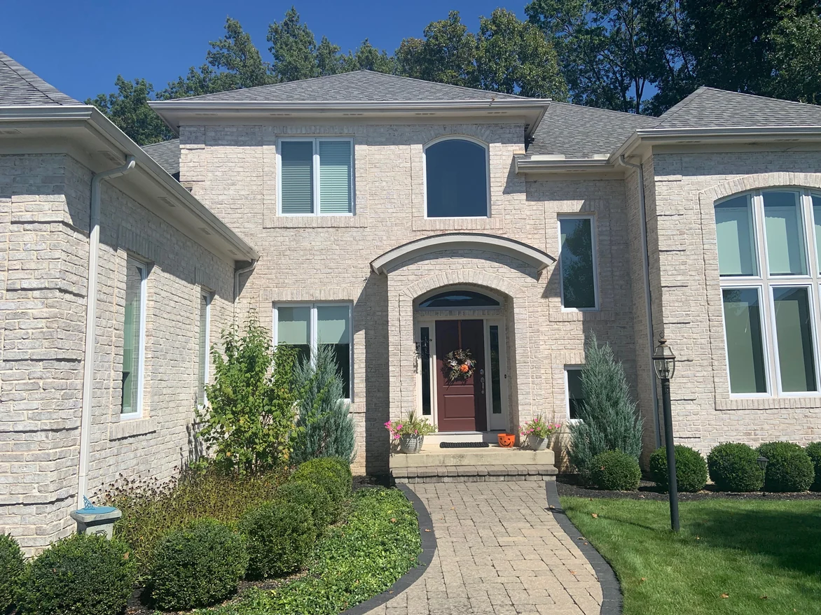 The arched entry and front door in 2019, the brick around the arch and the windows carrying the same cream and buff range