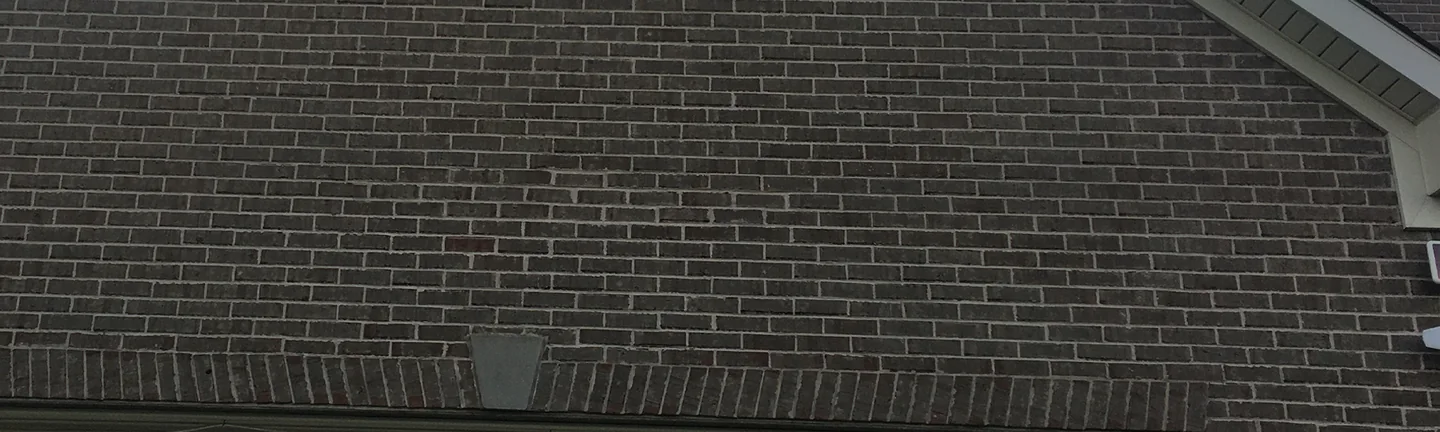 The garage gable in 2020, its grey brown brick running as one range down to the soldier course over the door