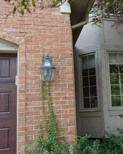 The front door and bay window of a Glenmoore, Michigan home in 2019, its brick one even range