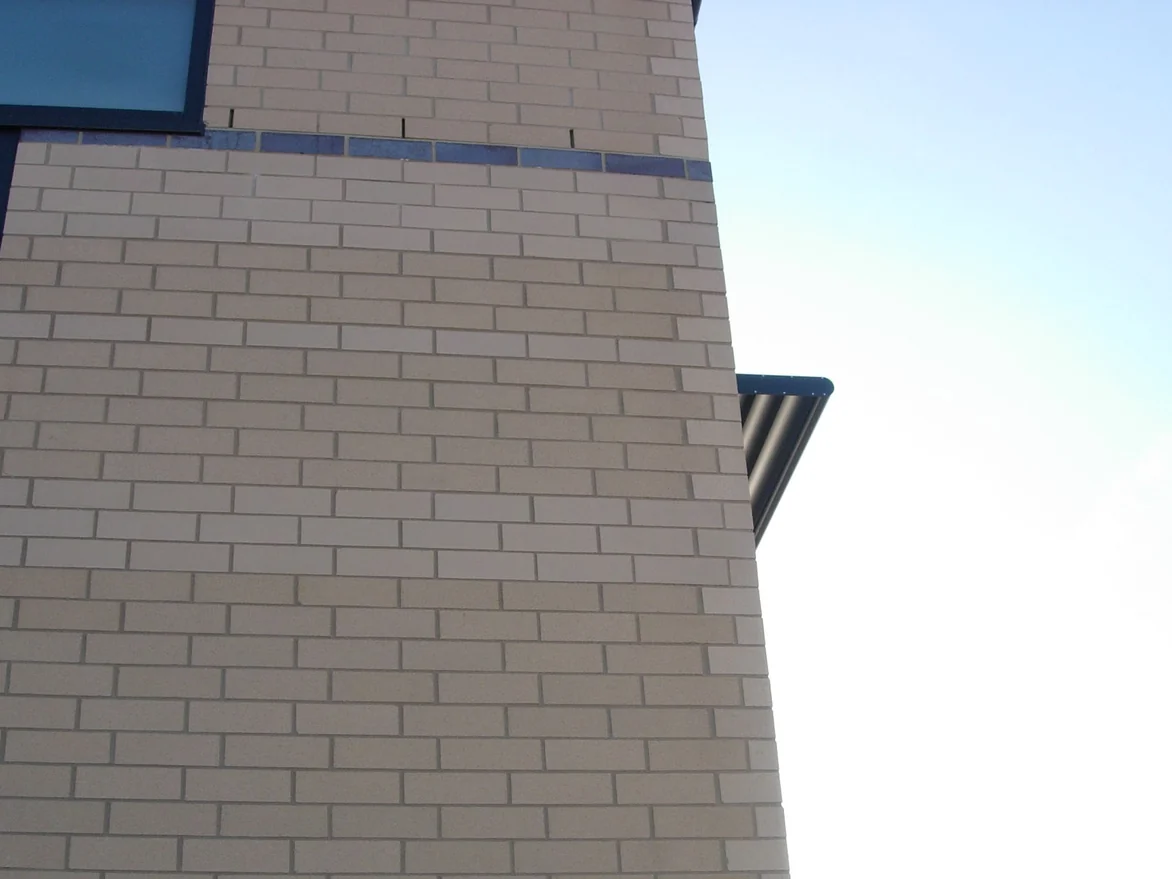 An outside corner of the office in 2008, the narrow brick return running up beside the flat wall a shade warmer than the face next to it