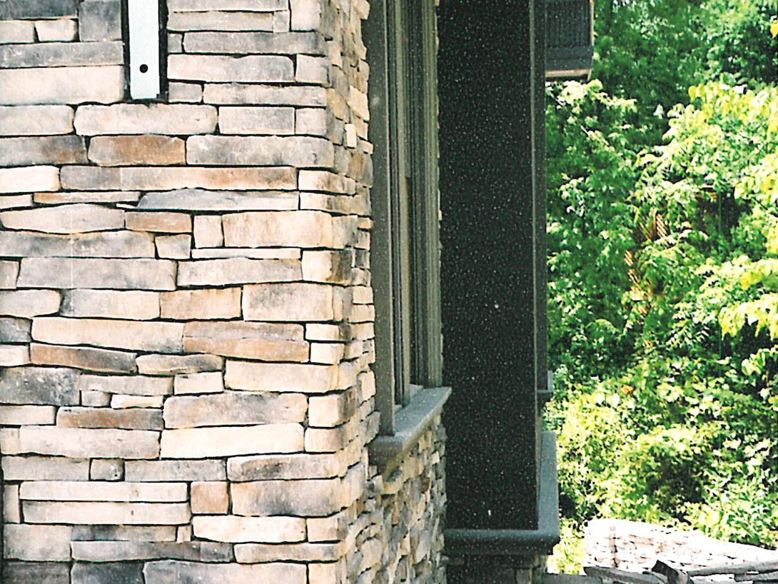 An outside corner of the house in 2003, the stone running cream and pale tan around the return beside a tall recessed opening