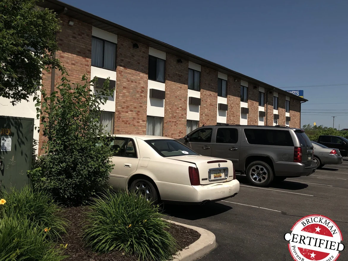 The guest room elevation from the parking lot in 2019, its brick one blend of red and brown across both floors, with the certification stamp in the corner of the frame