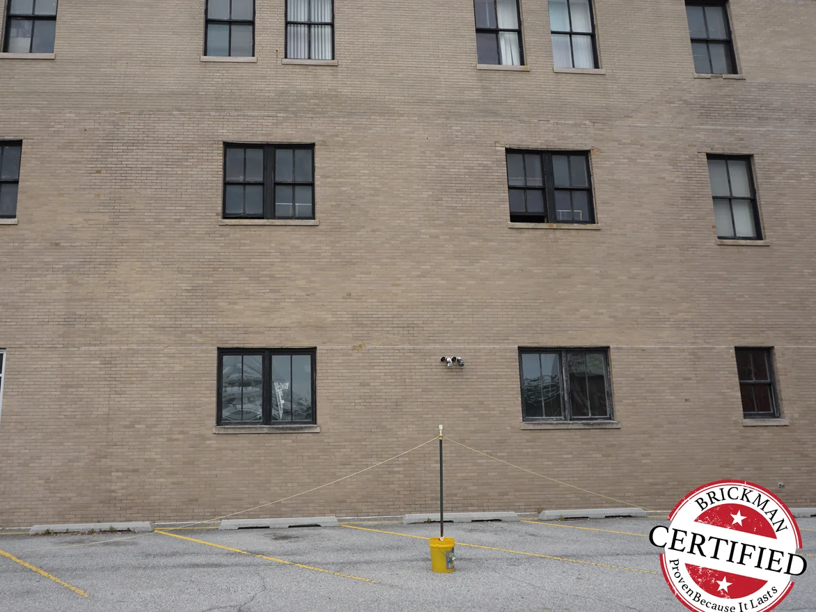 The main wall in 2019, the brick holding one buff range across every course between the window bays, the frame carrying the Brickman Certified stamp
