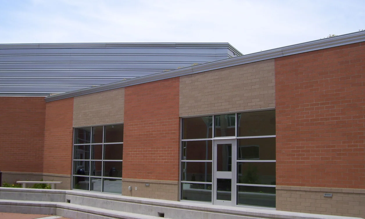 A high school courtyard in 2011, the panels above the windows lightened to tan against the orange brick around them