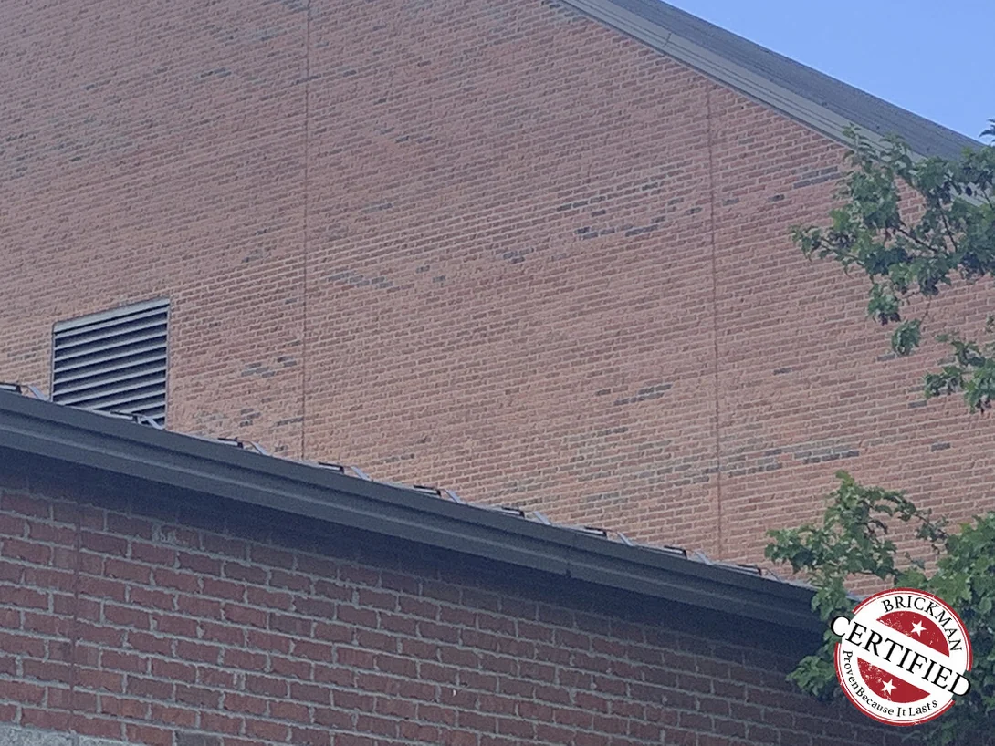 The gable and its louvred vent in 2019, carrying the Brickman certification stamp in the lower corner