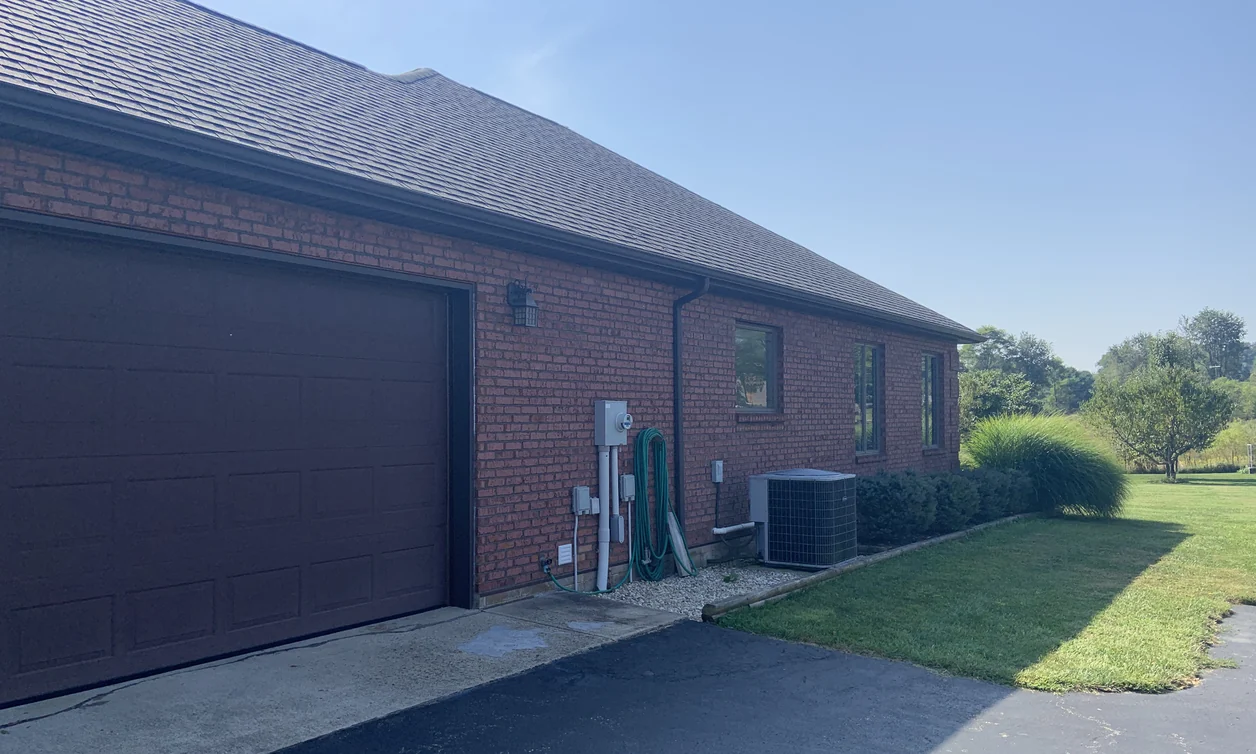 The garage side of a house in Hillsboro, Ohio in 2019, its brick one even range sixteen years after staining