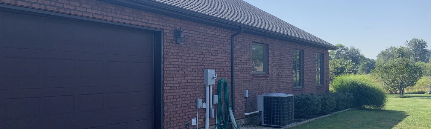The Hillsboro house from the driveway in 2019, the garage wall and the long brick wing reading as one range