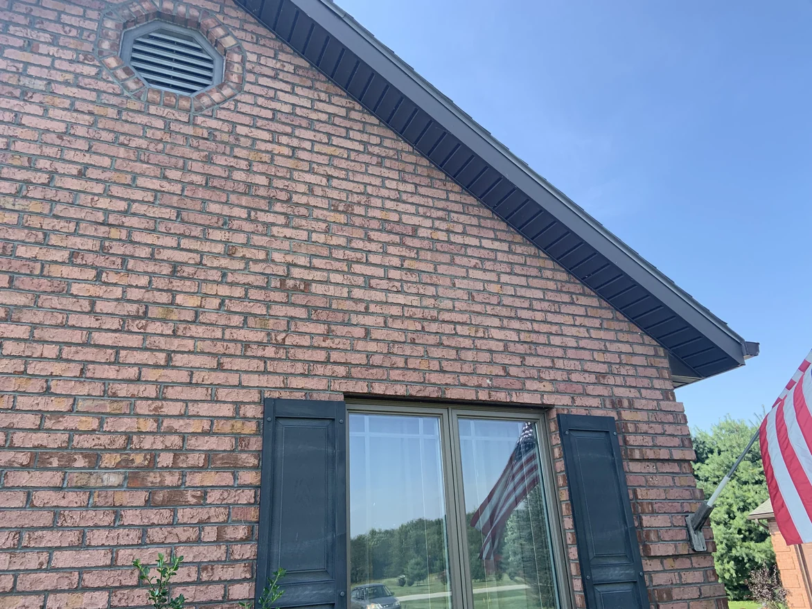 The gable wall in 2019 seen from below, an octagonal louvre vent set in brick that reads as one range up to the raking eave