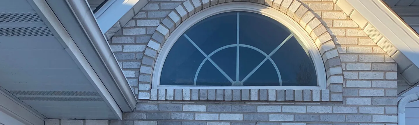 The brick gable over the front door of the Hobart house in 2021, the arched transom and the wall around it one range of pale grey