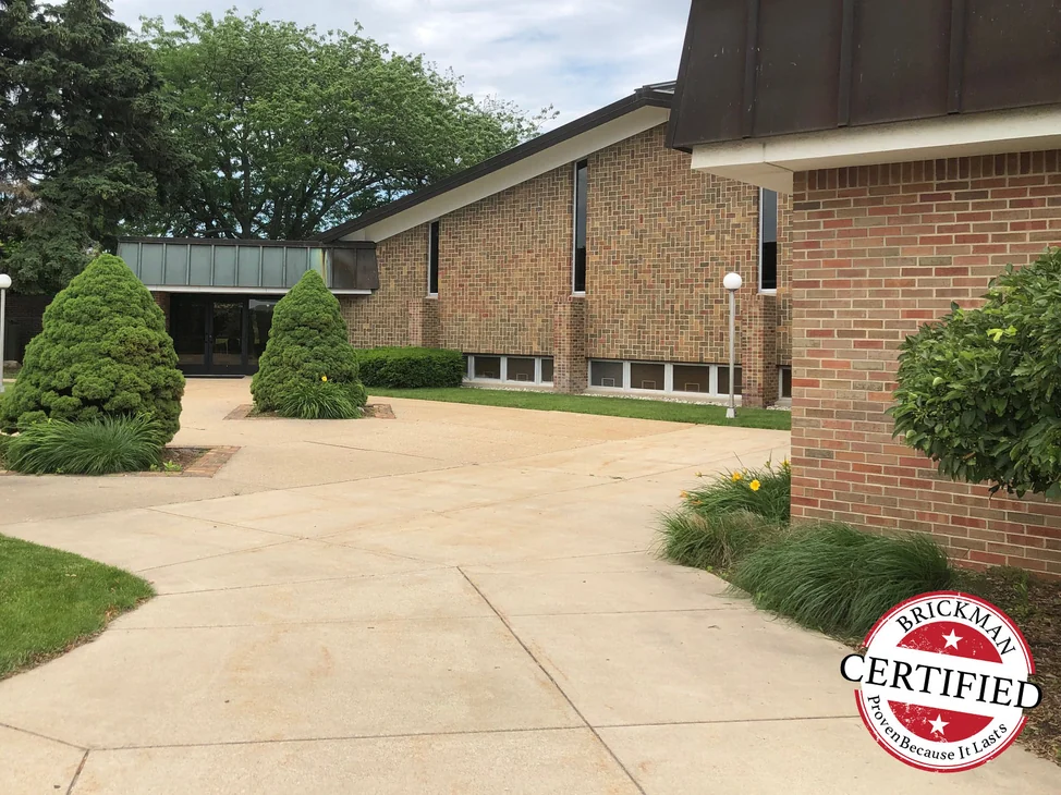 The church across its courtyard in 2019, the addition at the right and the older elevation beyond it reading as one brick blend