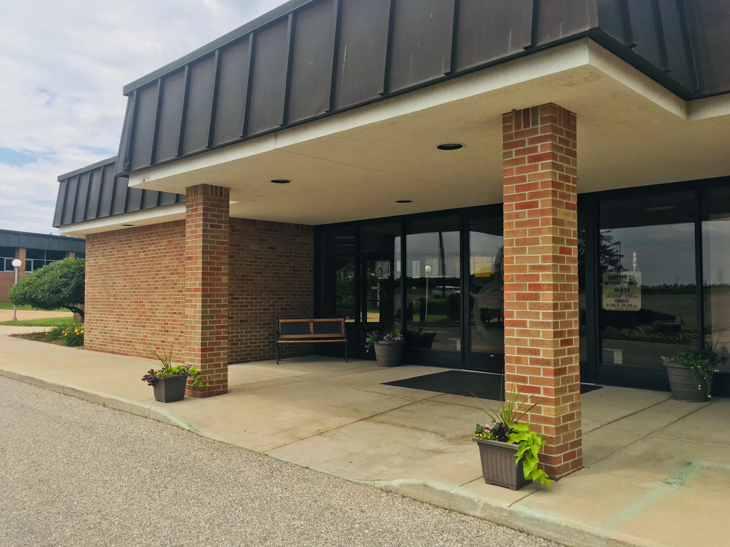 The entrance canopy in 2019 carried on two brick piers, the blend running from the piers into the wall behind the glass doors