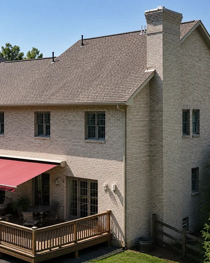 The same house 25 years later surrounded by mature trees, the stained brick still one even cream color