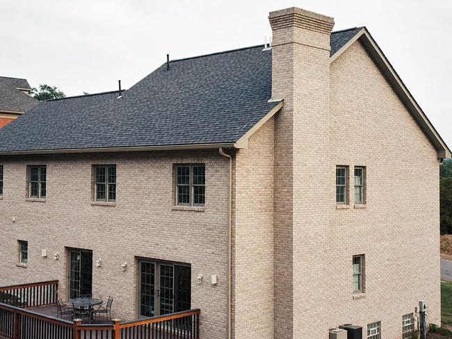 The same house after brick staining, the walls one even cream color and the deck finished