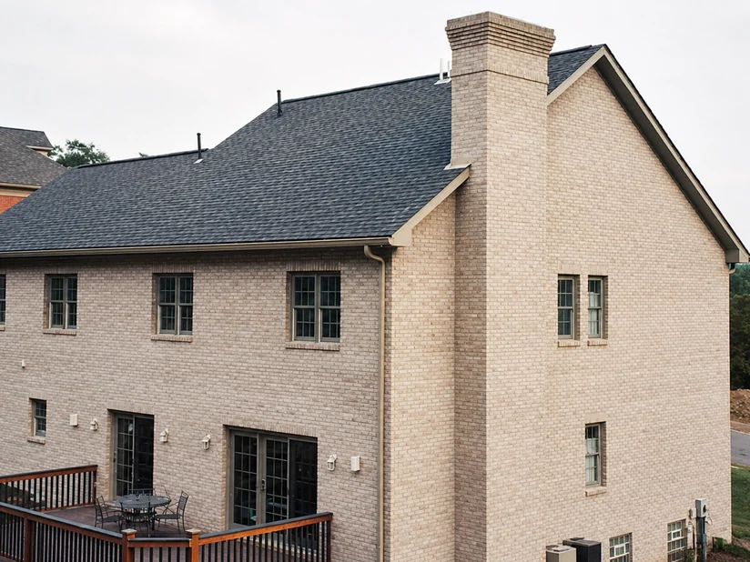 The same house after brick staining, the walls one even cream color and the deck finished