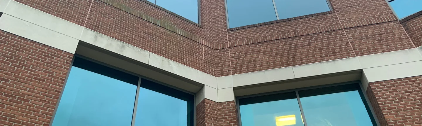 The clipped corner of the Hudson urgent care in 2019, red brick banding running one range across the upper floor and around the angle