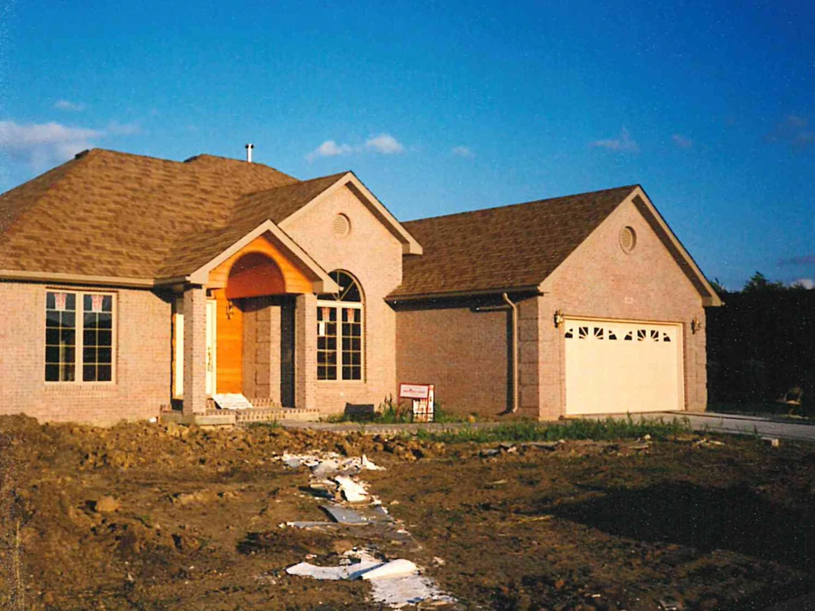 The front of the house from the driveway in the same period, the brick reading as one pale even range across both gables