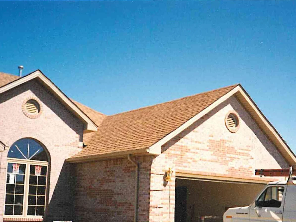 The garage gable and the wall beside it in the early 2000s, dark red and orange brick scattered through a pale range
