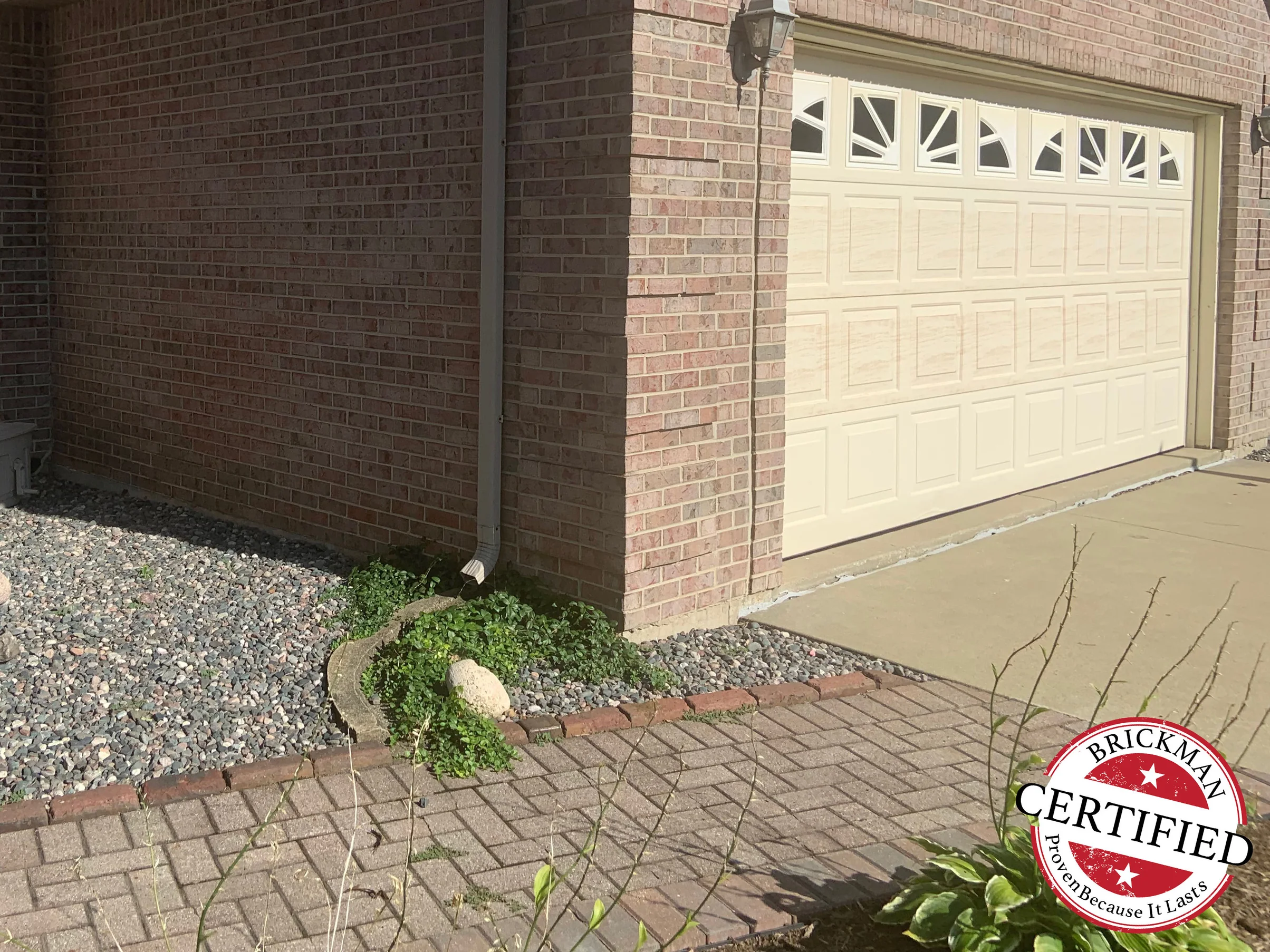 The garage bay and the return wall in 2019, the brick range even from the drive up to the eaves, with the certification stamp in the corner
