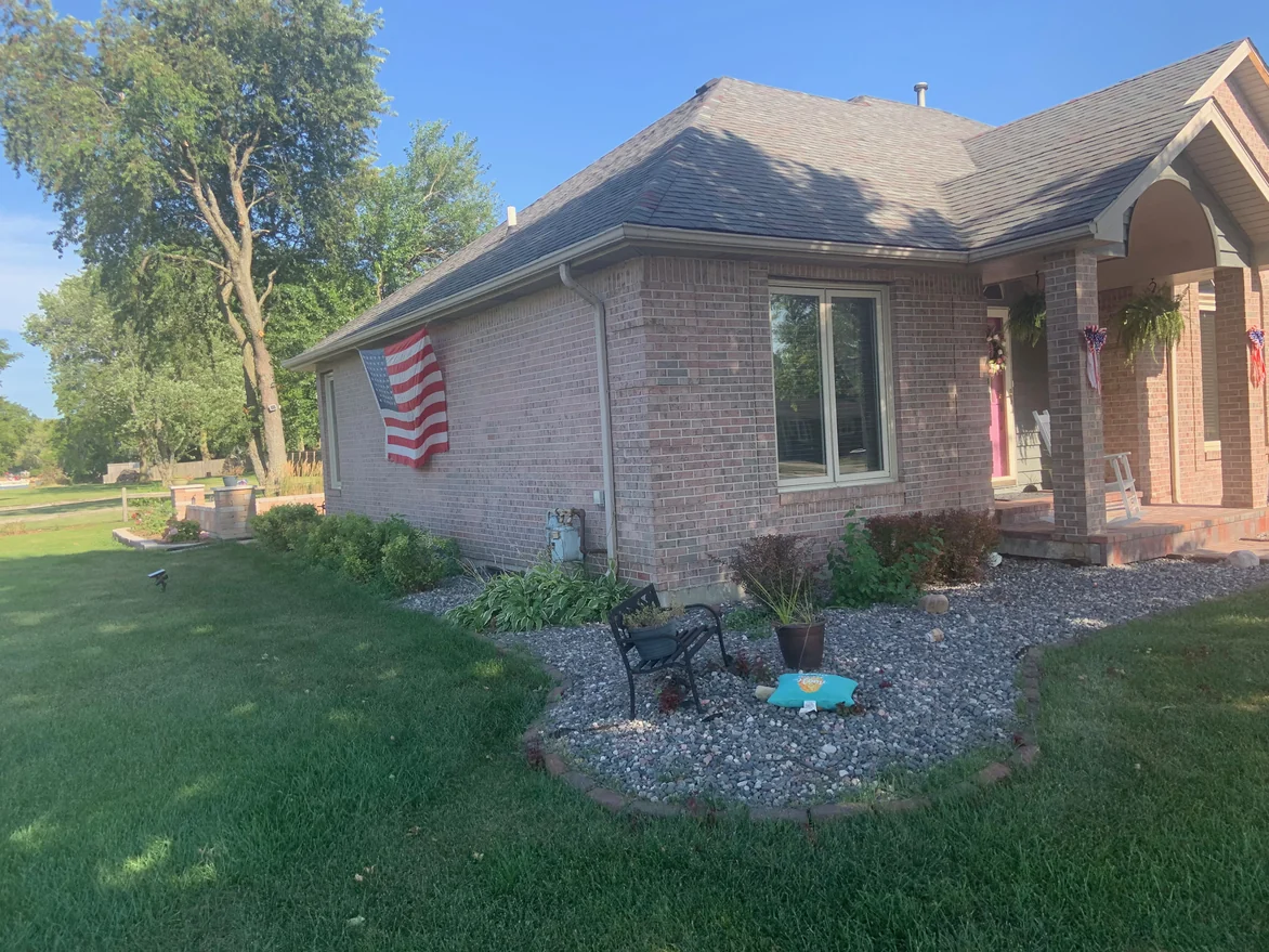 The side of the house in 2019, a flag hung on the brick, the range consistent along the whole elevation