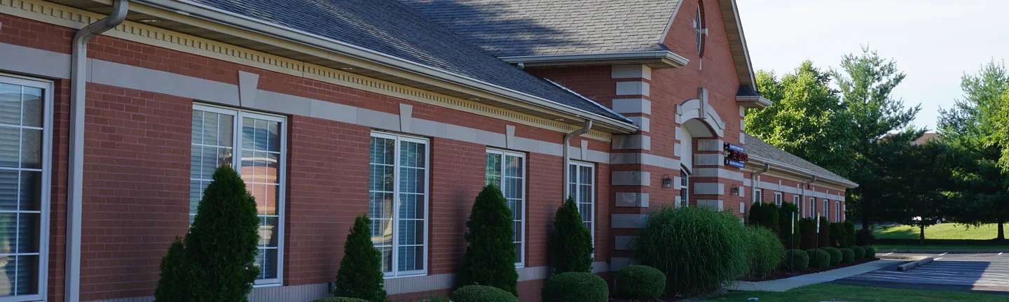 The business center in 2019, red brick with limestone quoins and a pale soldier course running below the windows