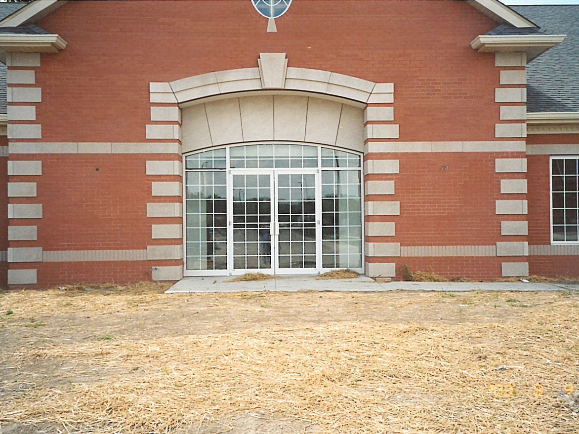 The arched glass entrance in 2003, the soldier course below the windows reading as pale stone against the same cream limestone