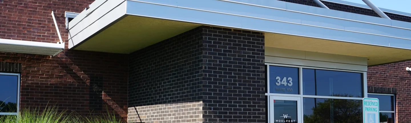 The corner of the Illinois office in 2019, its dark accent brick running as one even charcoal under a metal canopy