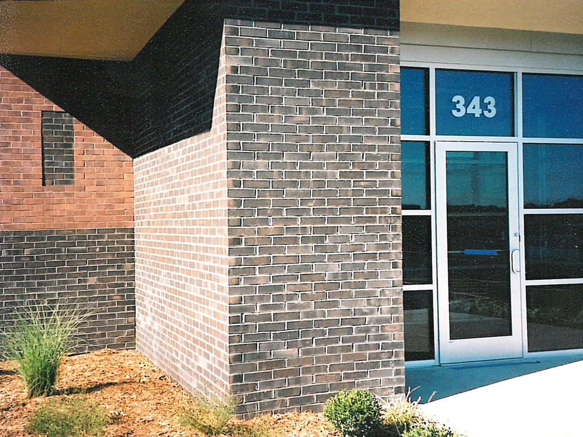 The brick pier at the second entrance in 2003, one face washed out to near cream and the other mottled grey and tan