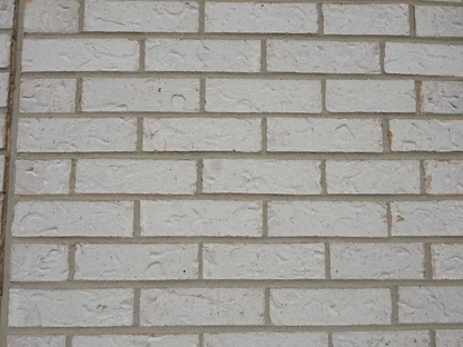 Close view of a white brick wall, the units an even white across pale mortar joints