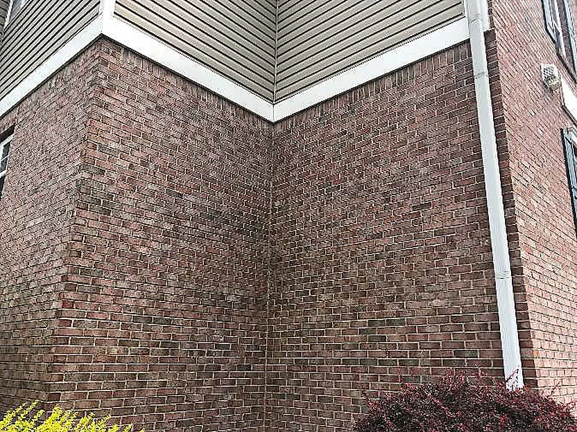 An inside corner of the building in 2019 under a sawtooth soffit, the brick on both walls in one range