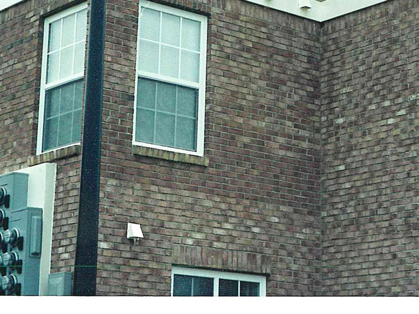 A window in the brick wall in 2002, the units around it running from pale pink to dark brown with no pattern