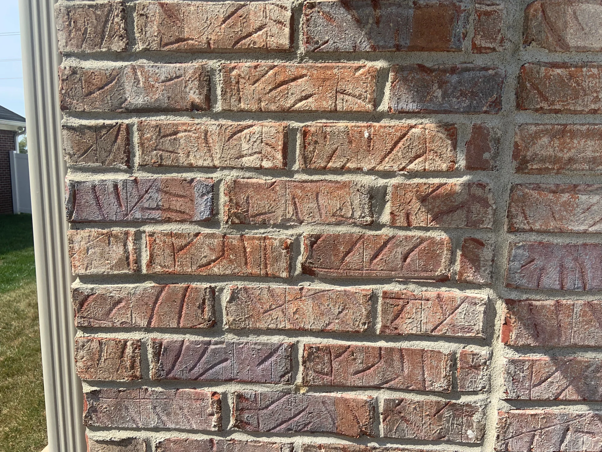 Close view of the brick at an outside corner in 2019, tan, cream, rust and slate units sitting together in one range