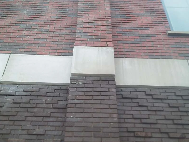 Looking up the wall in 2003 where the new second story meets the original, red and brown brick above a limestone band and flat dark brown brick below it