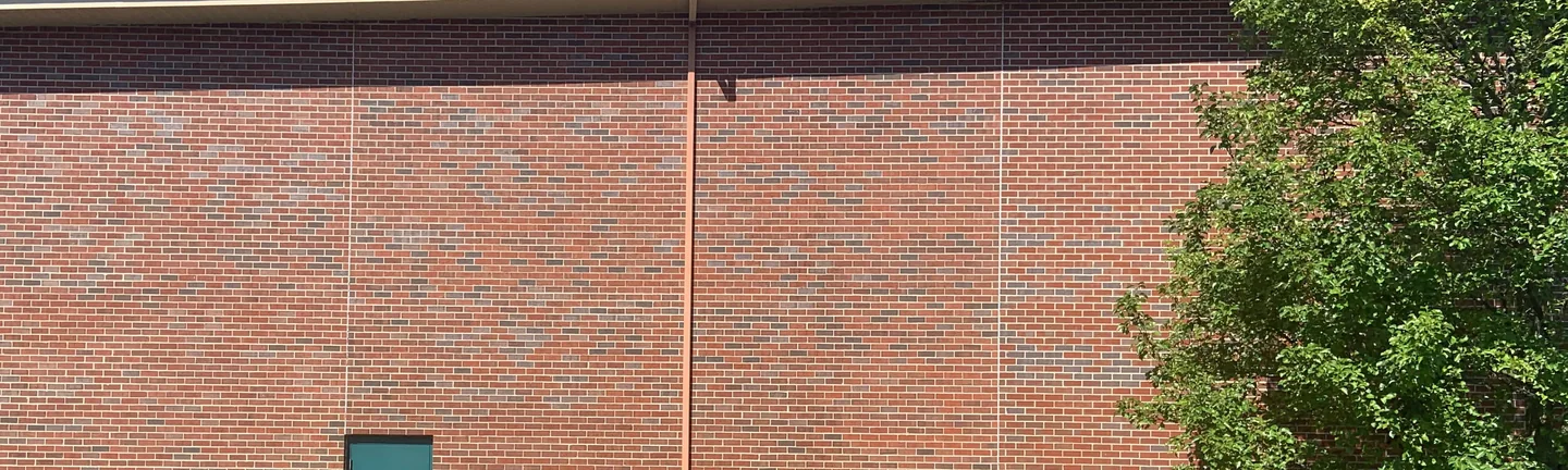 The stained elevation of the Indiana church in 2019, its brick reading as one even red and grey blend