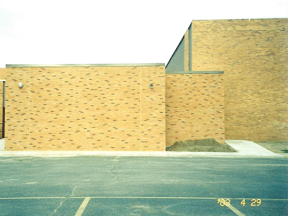 The same school wing later the same day, dark units now scattered across the whole wall in the pattern the older block behind it already had