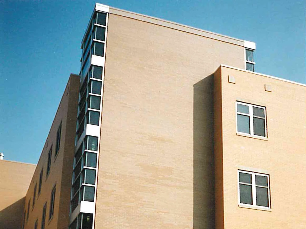 A tall blank brick wall on the hospital in 1996, its units a pale streaky cream against the orange brick of the wings on either side of it