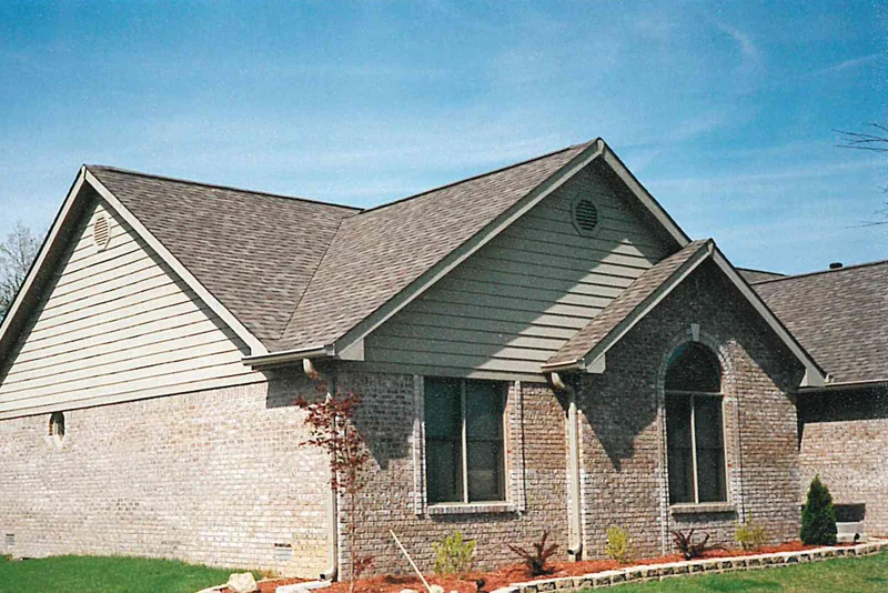 The house in May 1997, the brick running pale cream on one wall and a much darker grey brown on the next, with new planting in the beds below