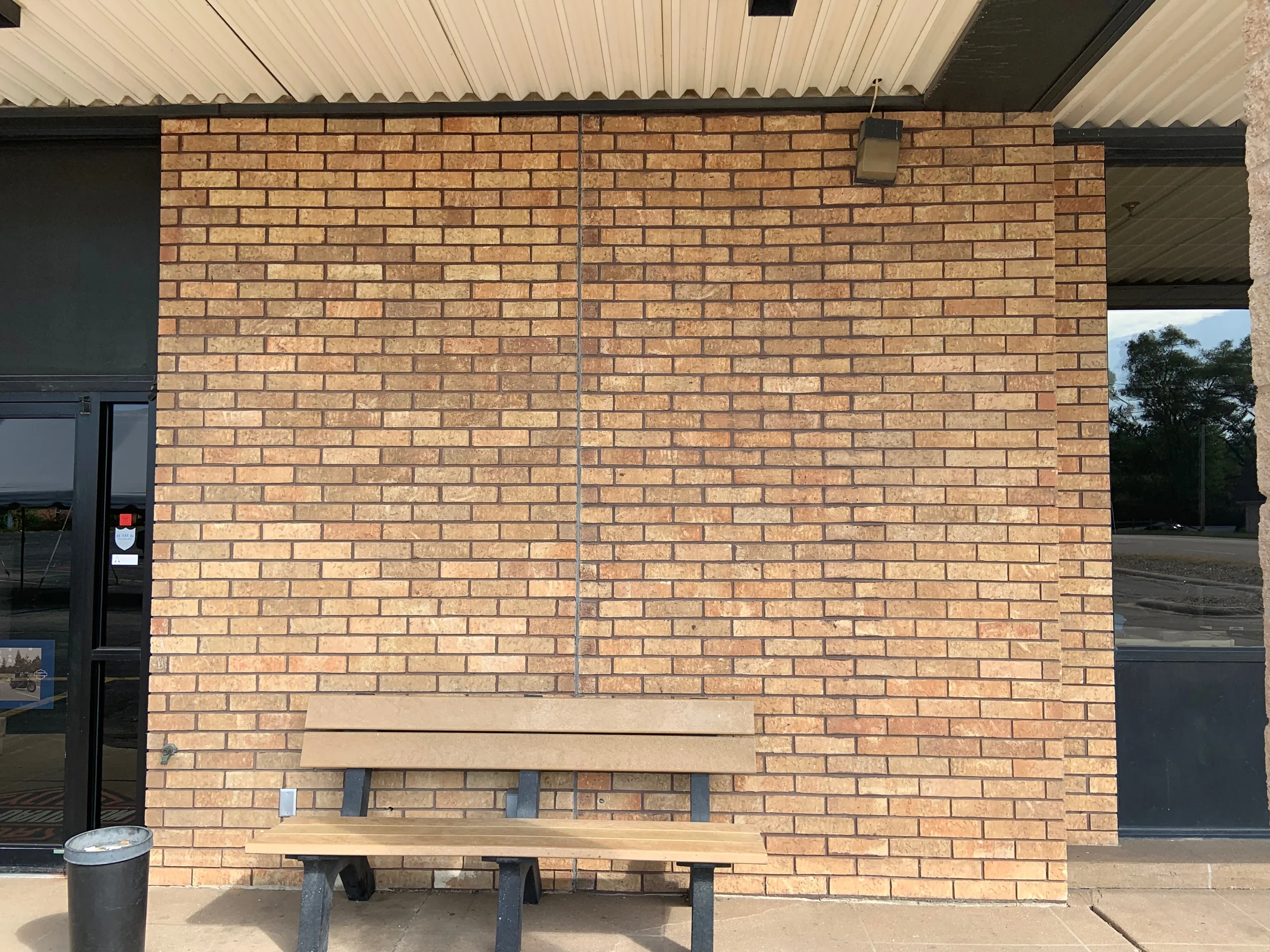 A panel of showroom brick between two doorways in 2019, the units an even range of cream, tan and orange across dark mortar joints