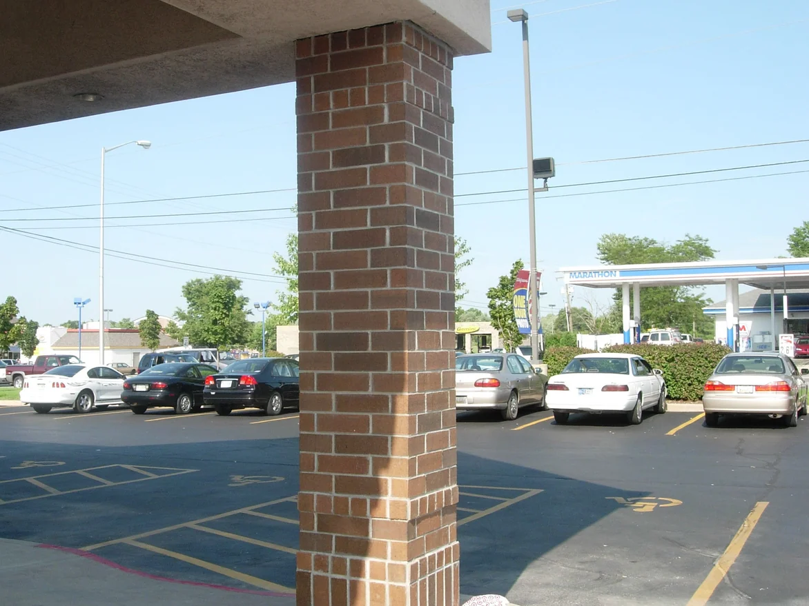 The same column photographed from the car park after staining, its brick now a red brown range with darker and lighter units through it